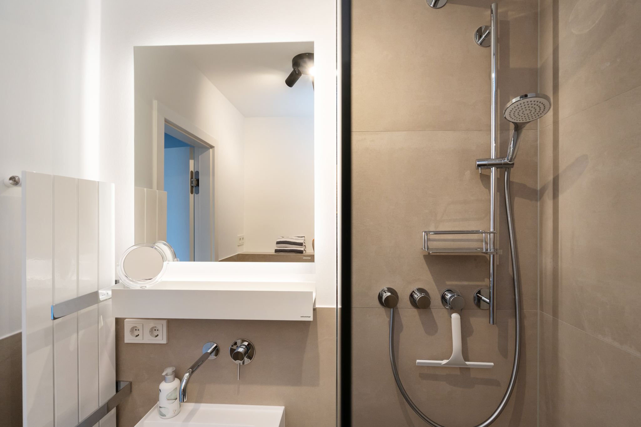 Dusche und Spiegel im Badezimmer der Ferienwohnung